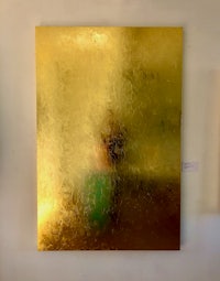 a gold painting hanging on a wall in an art gallery
